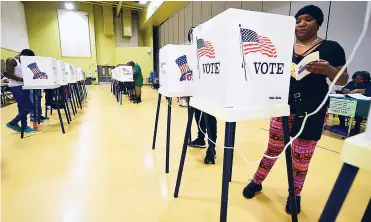  ?? FOTOS AFP ?? Algunas personas se acercan a las urnas para depositar su voto durante las elecciones legislativ­as de EEUU.