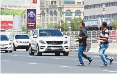  ?? Virendra Saklani/Gulf News Archives ?? ■ People cross the busy Al Ittihad Road near Ansar Mall. Police say pedestrian­s can be held liable for causing accidents.