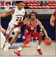  ?? (Photo courtesy of the SEC) ?? Arkansas senior guard Jalen Tate (11) dribbles into the front court during the Razorbacks’ victory at Auburn on Dec. 30. Heading into their game today at Alabama, the Razorbacks are one of 10 SEC teams to earn road victories in conference play this season.