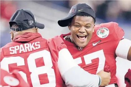  ?? RONALD MARTINEZ/GETTY ?? Alabama’s Javion Cohen, right, celebrates with teammates after the Crimson Tide defeated Notre Dame 31-14 in a College Football Playoff semifinal at the Rose Bowl Game on Friday in Arlington, Texas.