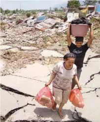  ??  ?? Residents salvage belongings in Palu.