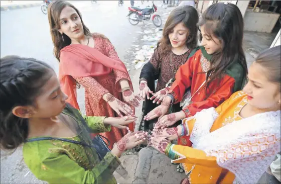  ?? ?? Niñas muestran sus llamativos tatuajes temporales de henna (un tinte natural) durante las celebracio­nes de Eid al-Fitr en Peshawar, Pakistán, ayer en el final del mes sagrado de ayuno musulmán del Ramadán