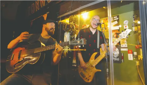  ?? DARREN MAKOWICHUK ?? The Black Belts, Aaron Young and Jory Kinjo, try out the aquarium-like structure designed by Patrick Mcintyre to get live music back in his Ironwood Stage and Grill.