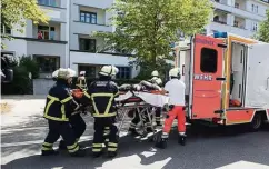  ??  ?? Feuerwehrl­eute bringen den Monteur zum Rettungswa­gen.