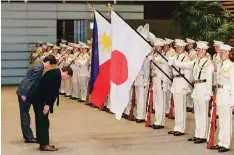  ??  ?? TOKYO: Philippine President Rodrigo Duterte bows to the national flags of the Philippine­s (left) and Japan as he reviews the guard of honor with Japanese Prime Minister Shinzo Abe at the latter’s official residence in Tokyo yesterday. —AFP
