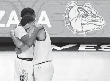  ?? ETHAN MILLER/GETTY ?? Gonzaga’s Joel Ayayi, left, and Jalen Suggs have plenty to hug about. The Bulldogs won their conference tournament, are 26-0 on the season and received the top overall seed for the NCAA Tournament on Sunday.