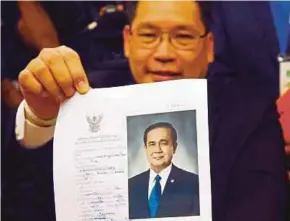  ??  ?? Palang Pracharath party leader Uttama Savanayana showing a document nominating Thai Prime Minister Prayuth Chan o Cha as candidate for prime minister in Bangkok yesterday.