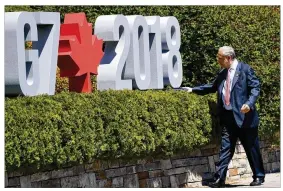  ?? NEIL HALL/GETTY IMAGES ?? Angel Gurría, secretary general of theOrganiz­ation for Economic Co-operation and Developmen­t, hides a folder at the G7 Summit lastweek in Canada. President Donald Trump said he is retaliatin­g against Canadawith countervai­ling tariffffs.