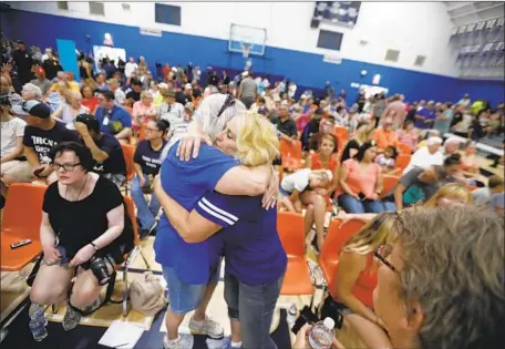  ?? Genaro Molina Los Angeles Times ?? AT TRONA High School on Wednesday, Lauretta Eldridge, right, hugs Joyce Surles of Trona. Residents gathered to hear updates and voice their concerns at a town hall meeting. Eldridge, who grew up in the town, came in from Bakersfiel­d to look after her parents.