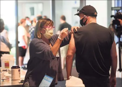  ?? Brian A. Pounds / Hearst Connecticu­t Media ?? Janet Cordova, RN, gives the J&J COVID-19 vaccine to Breck Austin, of Newtown, at a free vaccinatio­n clinic at the Hartford Healthcare Amphitheat­er in Bridgeport on Aug. 25. Austin, who is a truck driver, said he was getting the vaccine at his girlfriend's insistence.