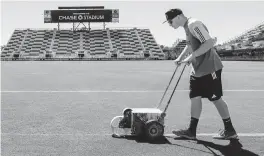  ?? MATIAS J. OCNER mocner@miamiheral­d.com ?? A staff member paints the field Tuesday at Inter Miami’s home, the newly renamed Chase Stadium in Fort Lauderdale. JPMorgan Chase will offer benefits to cardholder­s who attend Inter Miami games.