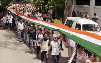  ?? — PRITAM BANDYOPADH­YAY ?? Members of People's Movement for Gorkhaland carry a 110-metre-long tricolour during a peace march from Rajghat to Jantar Mantar in New Delhi on Sunday to demand for a separate state.