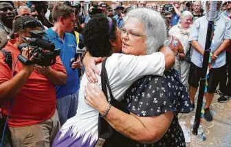  ?? Steve Helber / Associated Press ?? Susan Bro, mother of Heather Heyer, who was killed during last year’s Unite the Right rally in Charlottes­ville, embraces a supporter Sunday after laying flowers where her daughter was killed.
