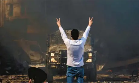  ?? ZAIN JAAFAR/GETTY-AFP ?? A Palestinia­n man flashes the victory sign at an Israeli military vehicle Wednesday in the West Bank.