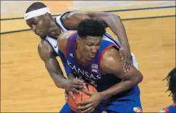  ?? ORLIN WAGNER ?? Kansas forward David McCormack (33) is fouled by Kansas State forward Makol Mawien, left, during the second half of an NCAA college basketball game in Manhattan, Kan., Saturday.