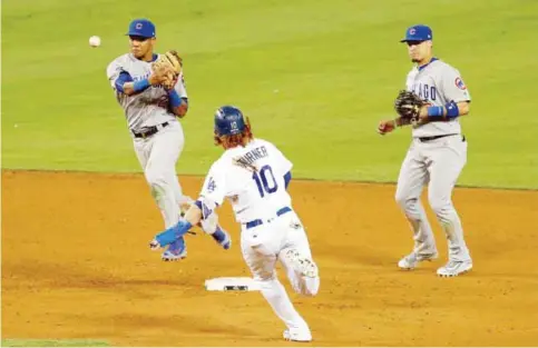  ??  ?? LOS ANGELES: Addison Russell #27 of the Chicago Cubs turns a double play as Justin Turner #10 of the Los Angeles Dodgers is out at second base in the eighth inning in game five of the National League Division Series at Dodger Stadium on Thursday in Los...