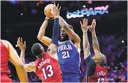  ?? MATT SLOCUM AP ?? Philadelph­ia’s Joel Embiid (21) goes up for a shot against Miami’s Bam Adebayo (13) and P.J. Tucker.