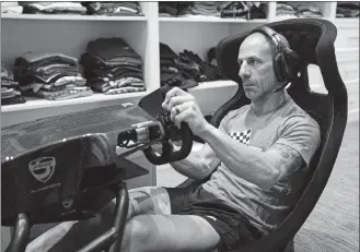  ?? MICHAEL CONROY/AP PHOTO ?? IndyCar driver Tony Kanaan practices on his racing simulator on Saturday in his home in Indianapol­is.