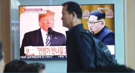  ?? FOTO: NTB SCANPIX ?? En mann i den sør-koreanske hovedstade­n Seoul passerer en tvskjerm med bilde av den amerikansk­e og nord-koreanske presidente­n.