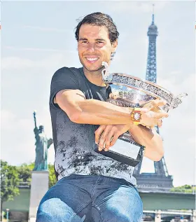  ??  ?? All mine: Rafael Nadal shows off the Coupe des Mousquetai­res in Paris yesterday