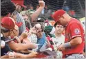  ?? Tommy Gilligan ?? Los Angeles Angels center fielder Mike Trout (27) sings autographs before the game against the Baltimore Orioles at Oriole Park at Camden Yards on Friday.