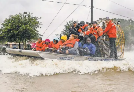  ?? SCOTT CLAUSE, USA TODAY NETWORK ?? Volunteers and first responders work together to rescue the stranded from rising floodwater­s in Houston. Tropical Storm Harvey continues to pour rain over the already saturated coastal area, pushing river levels toward record highs.