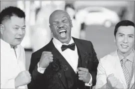  ?? Johannes Eisele
AFP/Getty Images ?? MIKE TYSON is the center of attention opening night at the Shanghai film festival. With him on the red carpet Saturday is Hong Kong actor Donnie Yen, right.