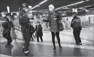  ?? MADRID
-AFP ?? A municipal police officer gives out free protective face masks at a metro station during the lockdown amid the coronaviru­s disease (COVID-19) outbreak in Madrid, Spain.