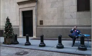  ?? AP/MARY ALTAFFER ?? A trader takes a break Tuesday outside the New York Stock Exchange, where stocks tumbled in a sell-off that began after a series of tweets by President Donald Trump, who warned China that “I am a Tariff Man.”