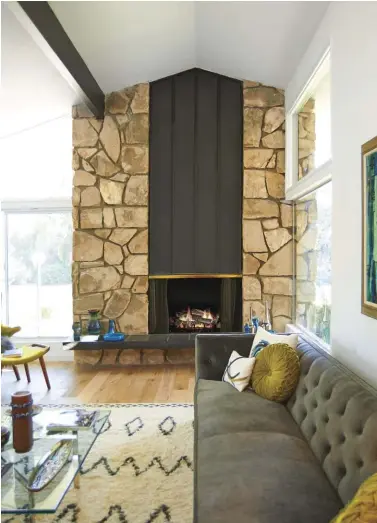  ??  ?? CLAD WITH ROCK, A FLOATING SLATE HEARTH AND PATINAED COPPER, THE SUNKEN LIVING ROOM’S FLOOR-TO-CEILING FIREPLACE STEALS THE SHOW—AND RIGHTFULLY SO. IT ACTUALLY HELPED CLAUDIA AND MICHALE FIND THE RIGHT CONTRACTOR TO WORK WITH, AS THEY FILTERED OUT...