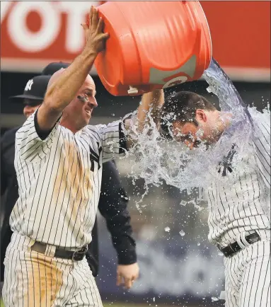  ?? Julie Jacobson / Associated Press ?? Brett Gardner, left, pours Gatorade on Neil Walker after Walker hit a walk-off single to drive in Gary Sanchez for the winning run against the Athletics during the 11th inning on Saturday.