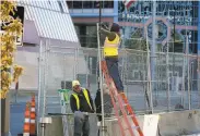  ?? Jim Mone / Associated Press ?? Workers install barbed wire and fencing Wednesday in Minneapoli­s as part of trial security.