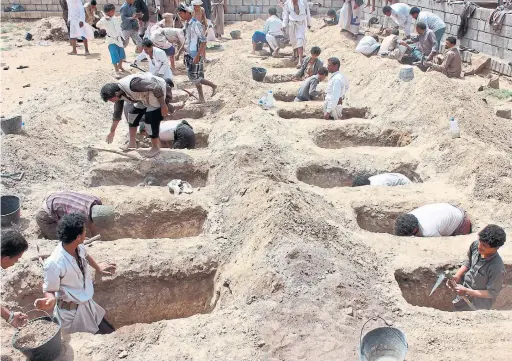  ?? AFP/GETTY IMAGES ?? Yemenis dig graves for children killed on Thursday when their bus was hit during a Saudi-led coalition airstrike in rebel-held northern Yemen.