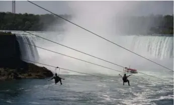  ?? DANIEL OTIS FOR THE TORONTO STAR ?? People shoot down the MistRider Zipline while the Hornblower brings people close to Niagara’s Horseshoe Falls.