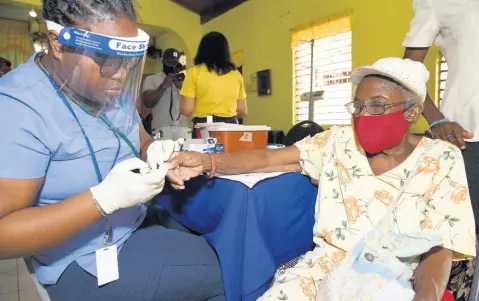  ?? FILE ?? Nurse Stephanie Morris administer­s a blood-sugar check on Patrice Ricketts, a 75-year-old diabetic from Commodore in Linstead, St Catherine, during a health fair sponsored by the Private Sector Organisati­on of Jamaica COVID-19 Jamaica Response Fund and the Council of Voluntary Social Services. The health Fair was held on July 4, 2020.