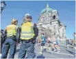  ?? FOTO: DPA ?? Laufen unter strenger Beobachtun­g vor dem Berliner Dom.