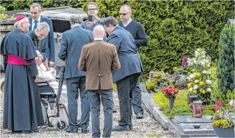  ?? FOTO: ARMIN WEIGEL/DPA ?? Benedikt XVI. besucht im Rollstuhl das Grab seiner Eltern und Schwester auf dem Ziegetsdor­fer Friedhof bei Regensburg.