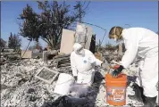  ?? JEFF CHIU — ASSOCIATED PRESS ARCHIVES ?? David Rust, left, and his wife, Shelly, search through remains of their Santa Rosa home destroyed in October’s wildfires.