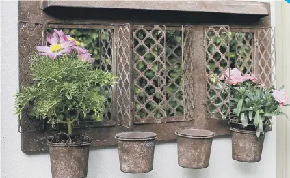  ??  ?? Rustic outdoor garden mirror with four planters.