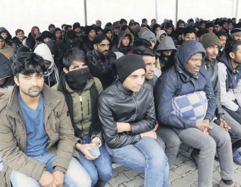  ??  ?? A group of illegal migrants sit under a tent in this file photo showing migrants intercepte­d by Turkish security forces in Edirne, a main land route to Europe from Turkey.