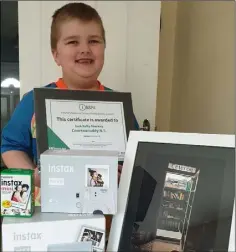  ??  ?? Jack Kelly-Sharkey with his winning certificat­e, prizes and a copy of his photo that earned his first place