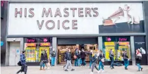  ?? — AFP ?? In this file photo pedestrian­s walk past a HMV store in central London.