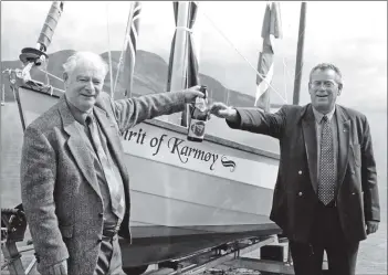  ?? 01_B34twe04 ?? Councillor John Sillars and Vice-Mayor of Karmoy Astor Damm open a bottle of wine to celebrate the launch of a longboat called the Spirit of Karmoy. The vice-mayor and associates from Norway were visiting the Largs Viking Festival and visited Arran to...