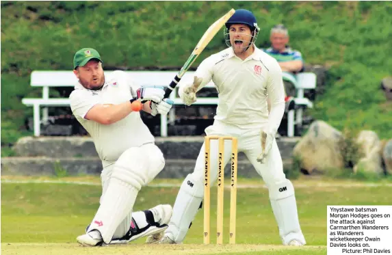  ?? Picture: Phil Davies ?? Ynystawe batsman Morgan Hodges goes on the attack against Carmarthen Wanderers as Wanderers wicketkeep­er Owain Davies looks on.