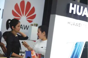  ?? SOMCHAI POOMLARD ?? A Huawei saleswoman helps a visitor at the company’s booth during Thailand Mobile Expo 2019 at Bitec.