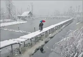  ?? AP/DAR YASIN ?? A Kashmiri man walks on a snow-covered footbridge in Srinagar, December 2019. This is part of a series of images by Associated Press photograph­ers from J&K -- Dar Yasin, Mukhtar Khan and Channi Anand -who won the Pulitzer Prize for taking ‘striking images of life’.