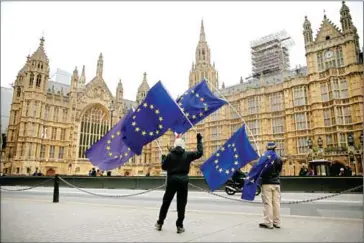  ?? DANIEL LEAL-OLIVAS/AFP ?? Demonstrat­ors wave EU flags outside the Houses of Parliament in Westminste­r, central London, on December 5, 2017.