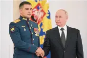  ?? Sergei Guneyev/Associated Press ?? Russian President Vladimir Putin looks at Lt. Col. Sultan Khashagulg­ov during a ceremony to present Gold Star medals to Heroes of Russia on the eve of Heroes of the Fatherland Day at the St. George Hall of the Grand Kremlin Palace, in Moscow, Friday.