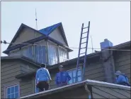  ?? COURTESY OF TRAVIS FREES ?? Workmen from The Helping Company, a Reading roofing contractor, install new roof on the Berks Military History Museum, a Mohnton landmark built in 1873. The company is doing the work free of charge.