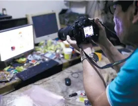  ?? FOTO AP ?? RAID. A National Bureau of Investigat­ion (NBI) operative takes a picture of the computer of suspected pedophile David Timothy Deakin during a raid at his home in Pampanga.